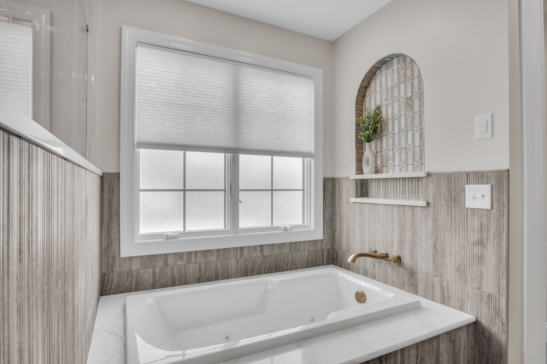 A bathroom with a jacuzzi tub and a window.