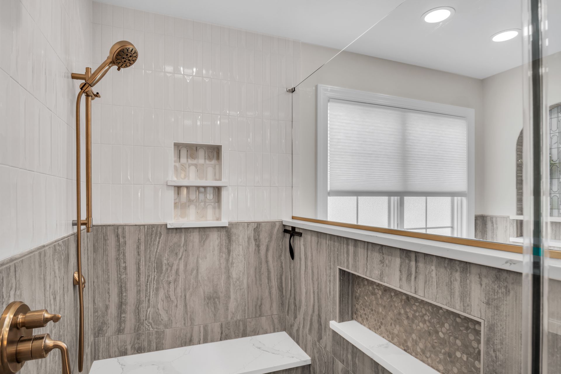 A bathroom with a walk in shower and a window.