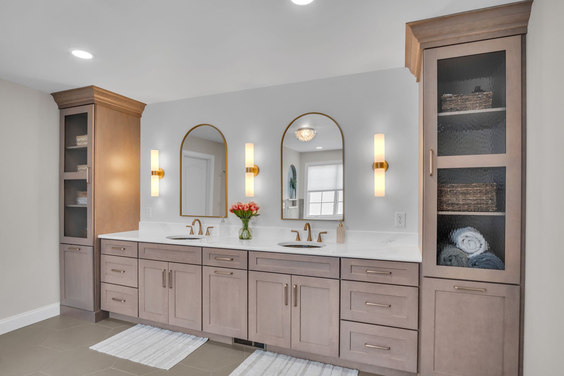 A bathroom with two sinks , two mirrors , and lots of cabinets.