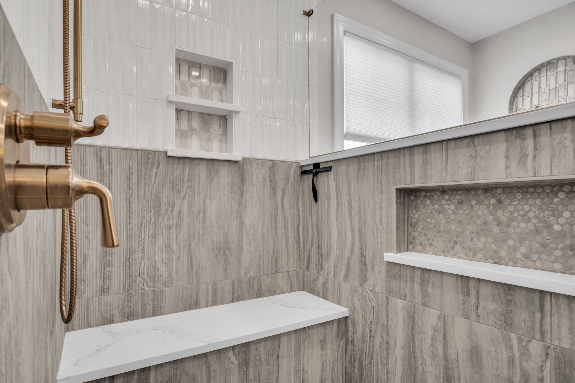 A bathroom with a walk in shower and a window.