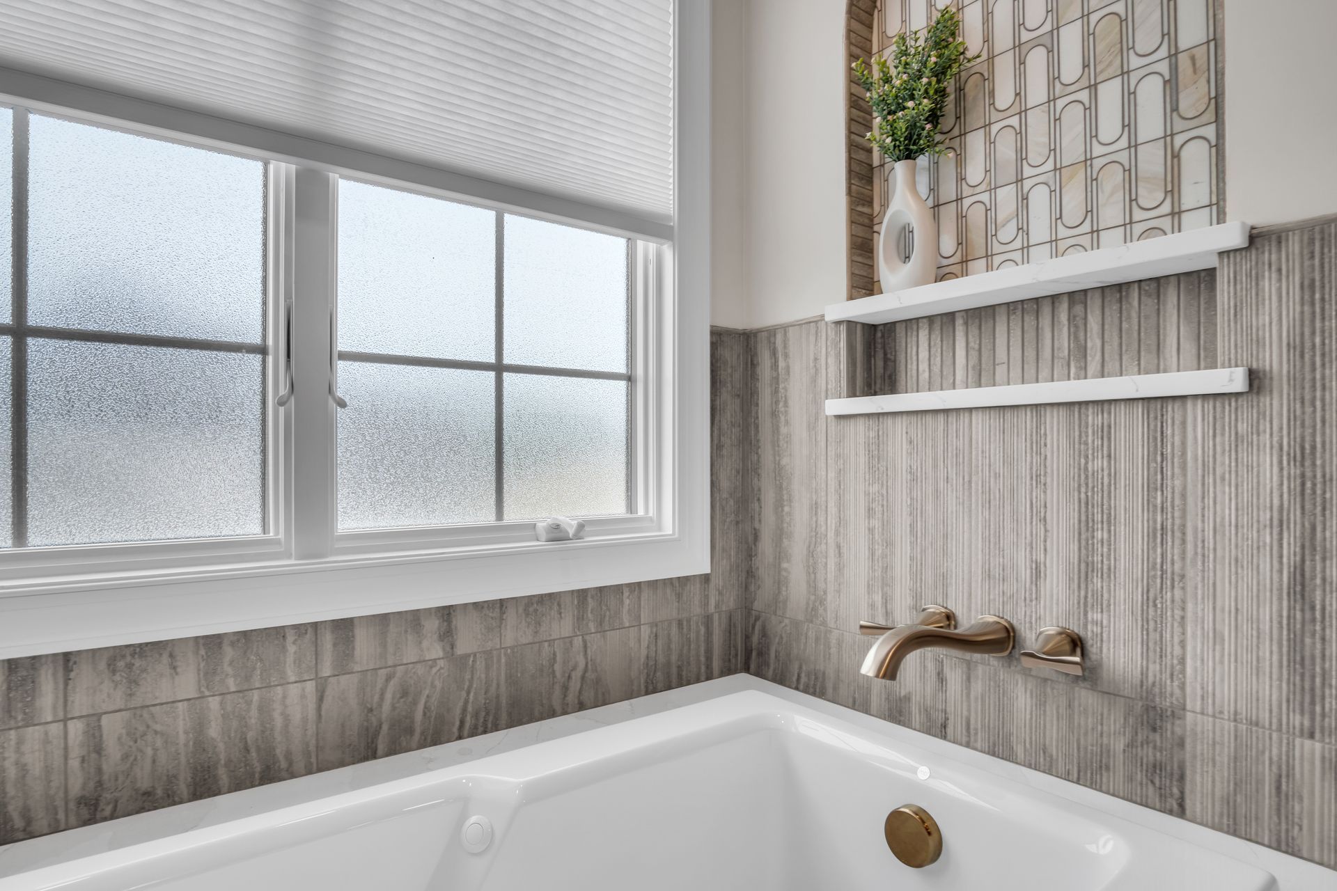 A bathroom with a bathtub and a window.