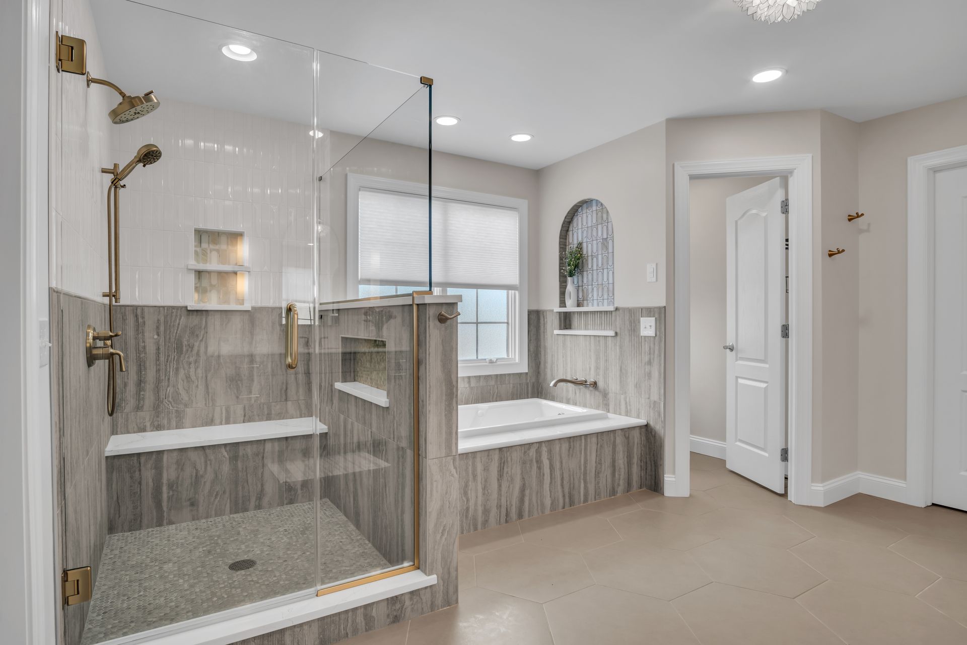 A bathroom with a walk in shower , tub , and window.