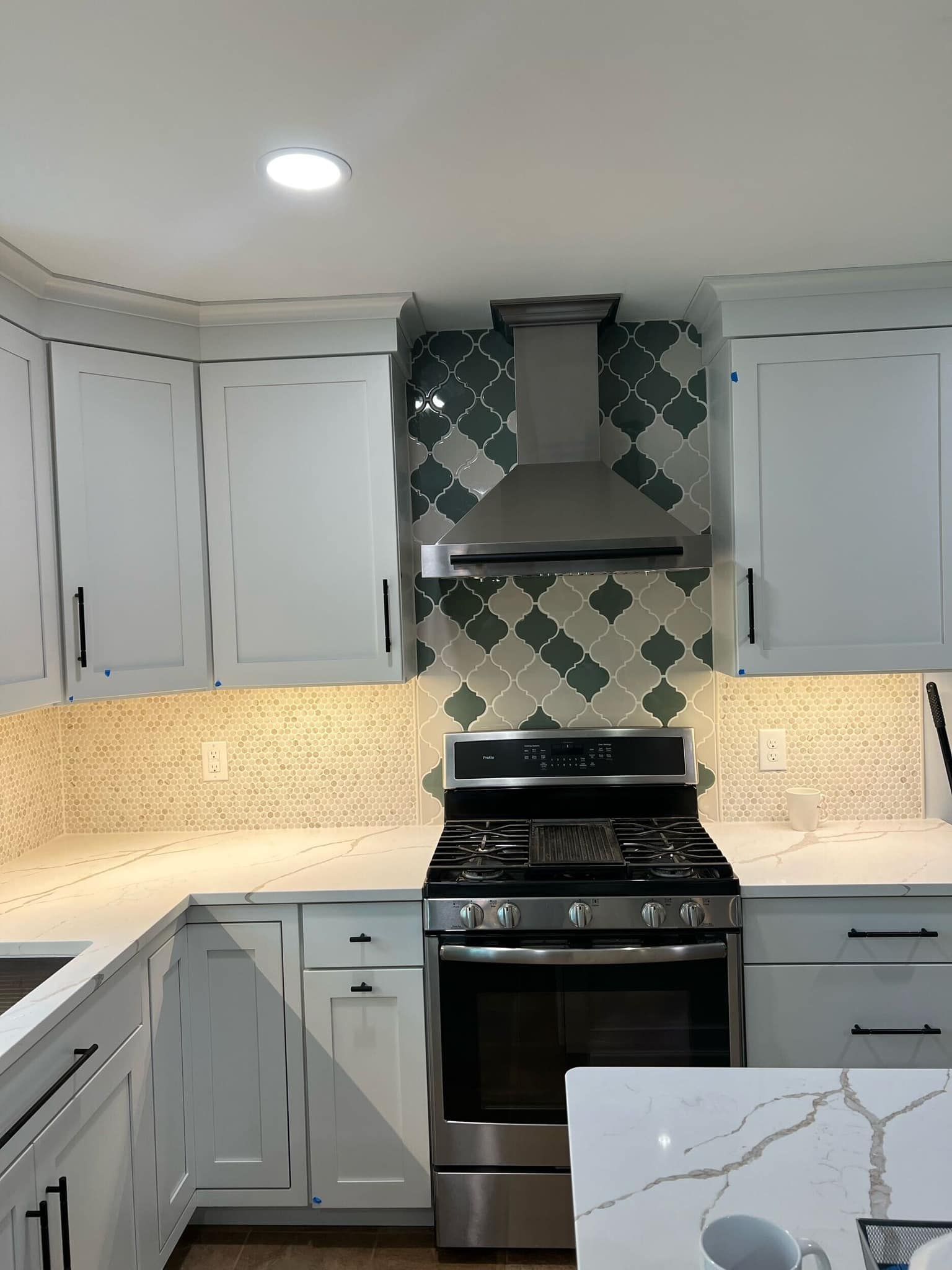 A kitchen with stainless steel appliances and white cabinets