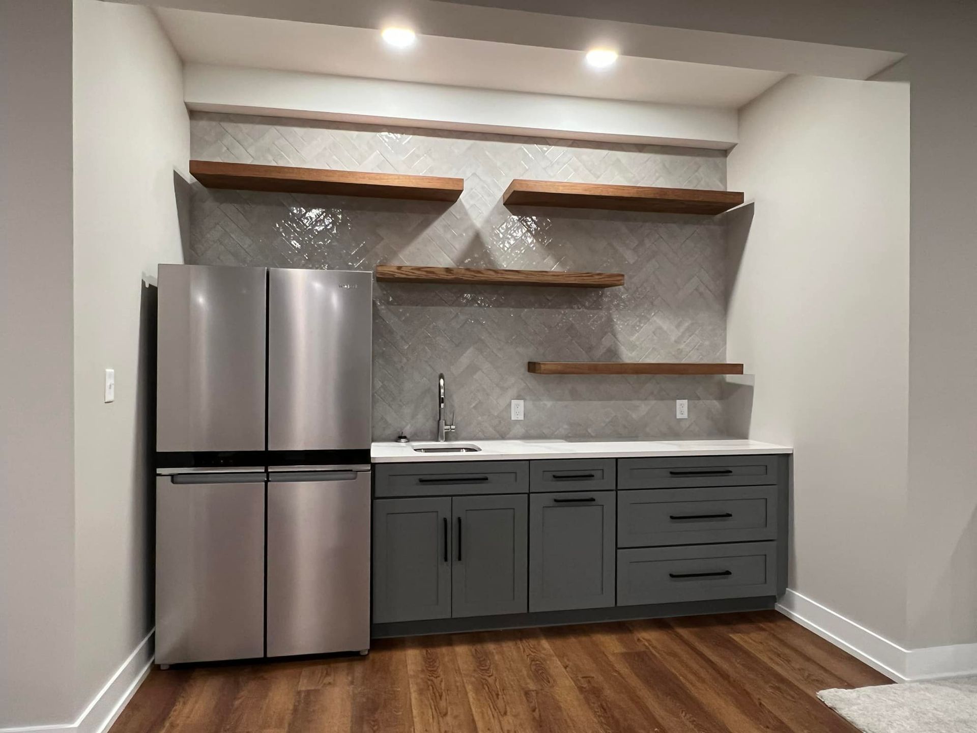 A kitchen with stainless steel appliances and gray cabinets