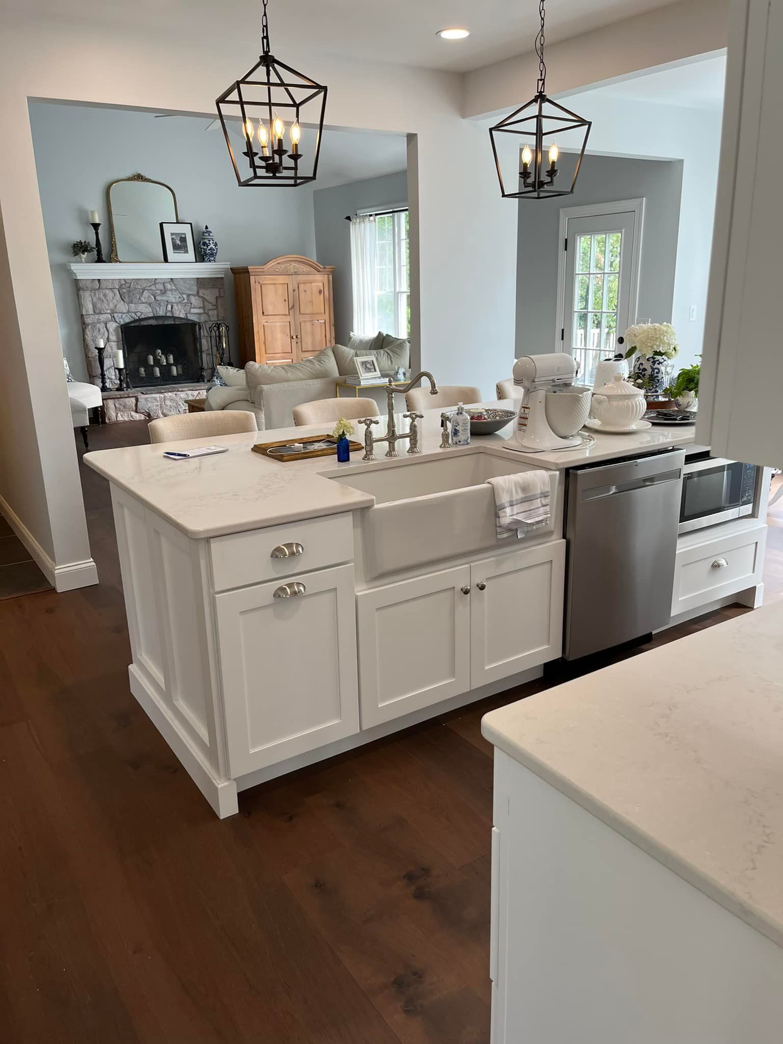 A kitchen with white cabinets , a sink , and a dishwasher.