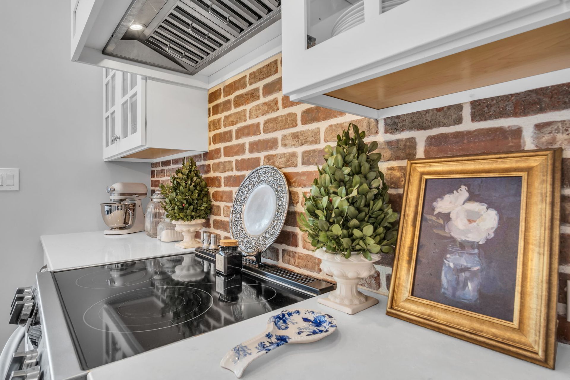 A kitchen with a stove and a picture on the counter.