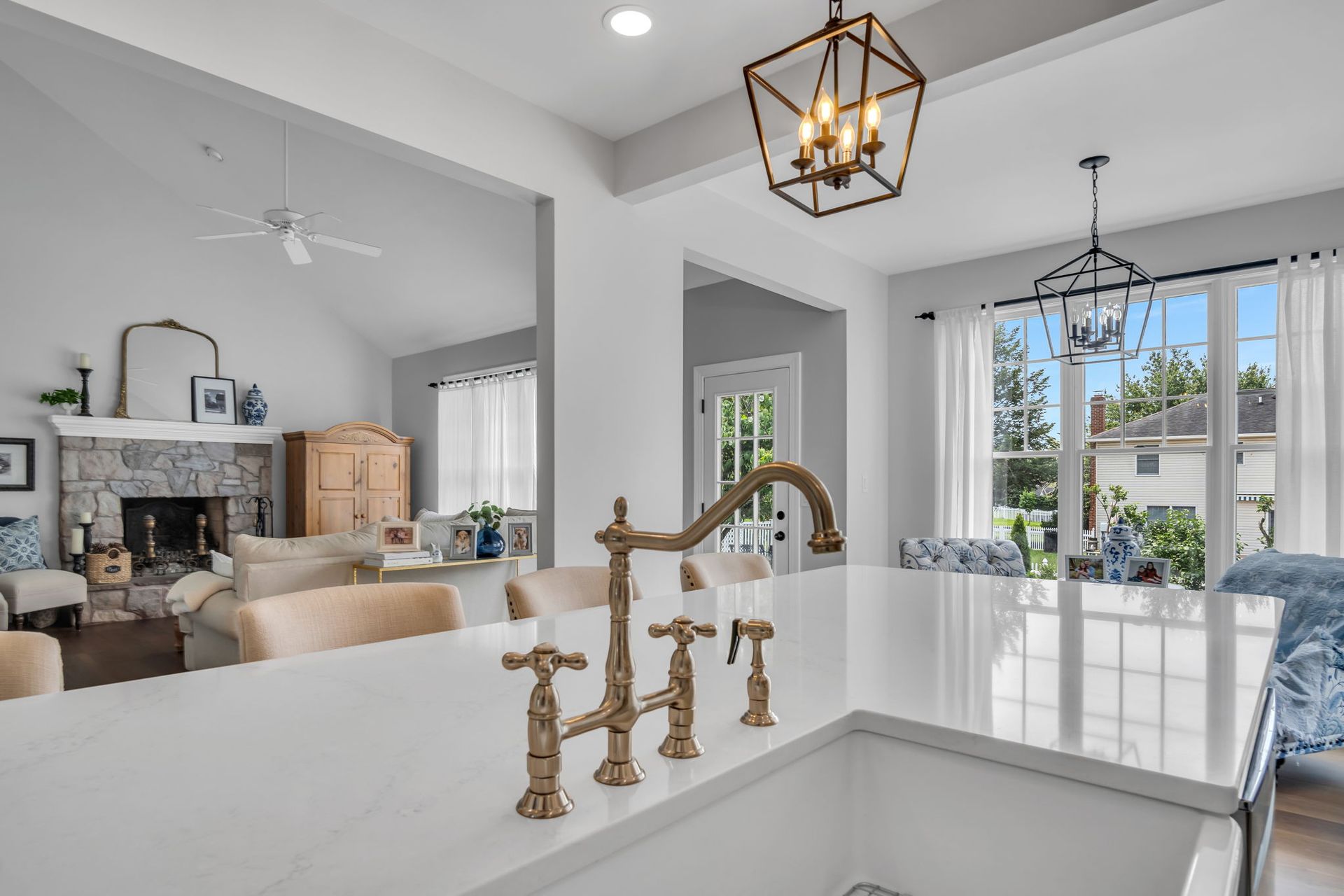 A kitchen with a sink , faucet , and chandelier.
