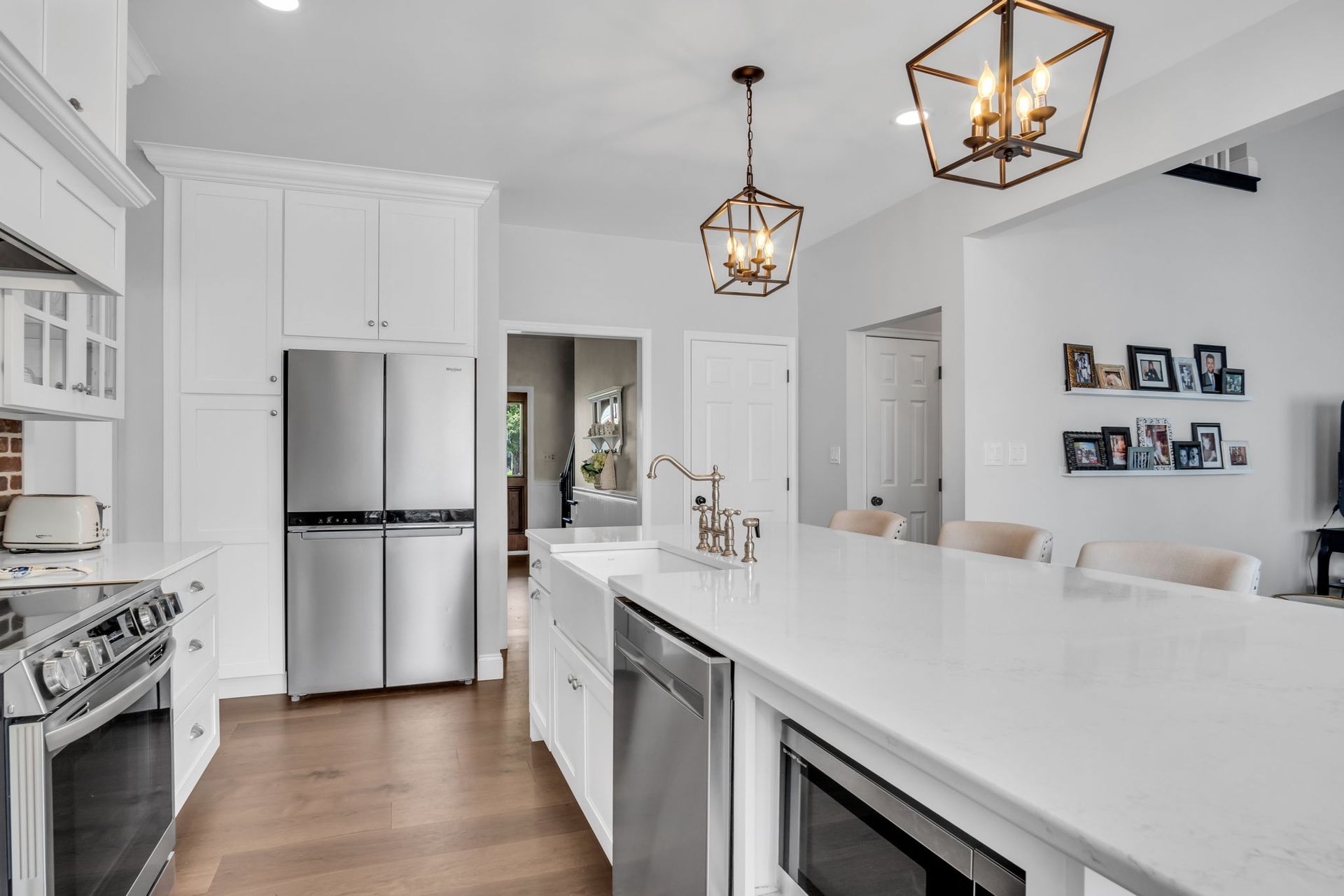 A kitchen with white cabinets , stainless steel appliances and a large island.