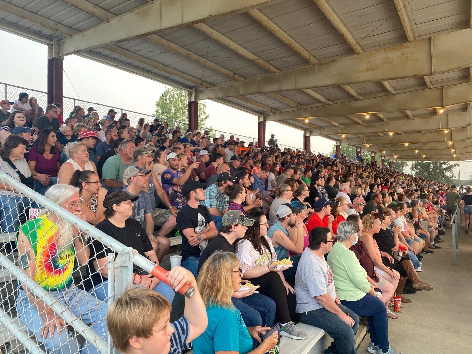 A large crowd of people are sitting in a stadium watching a game.