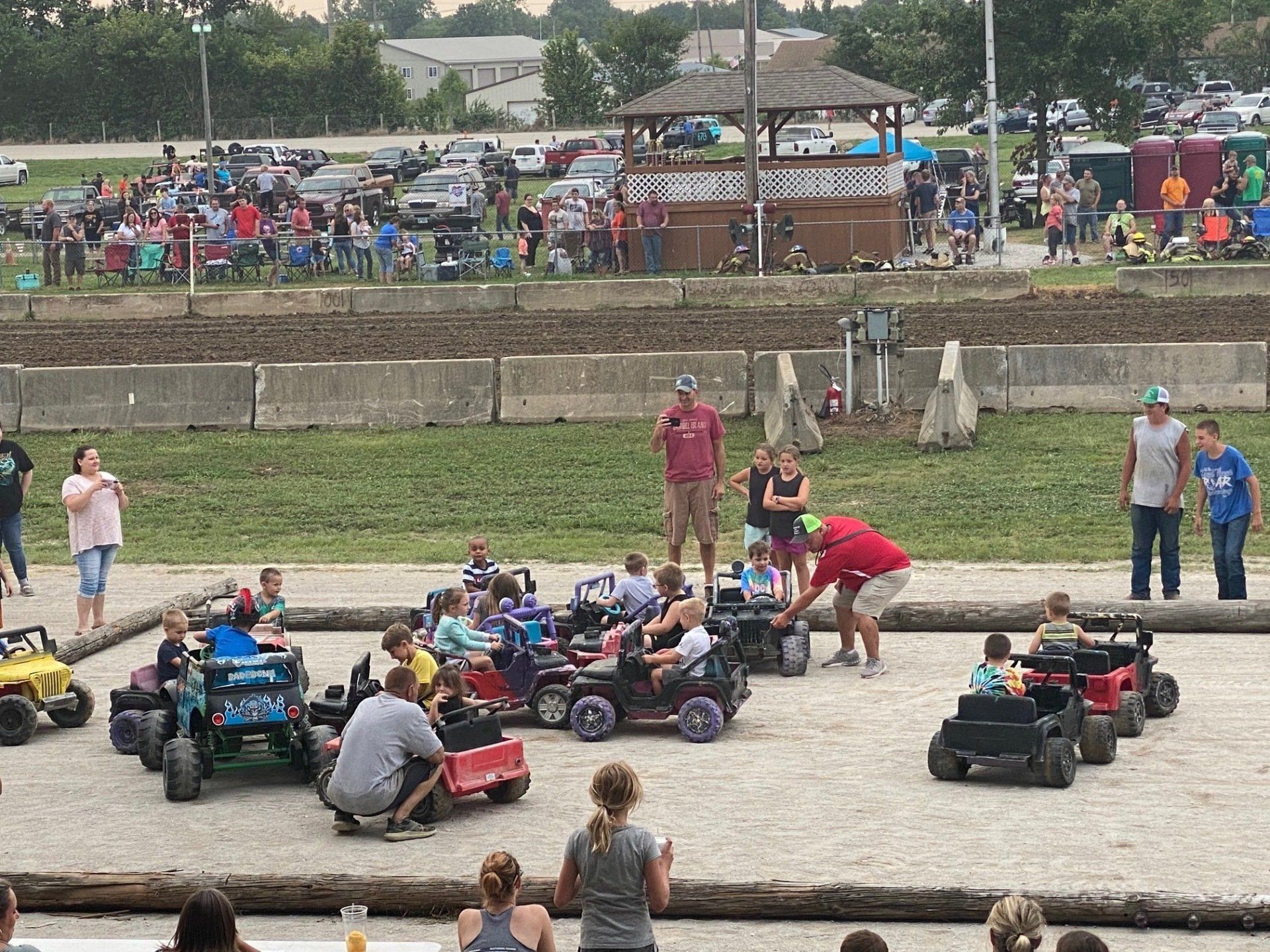 A group of people are riding toy cars on a track.