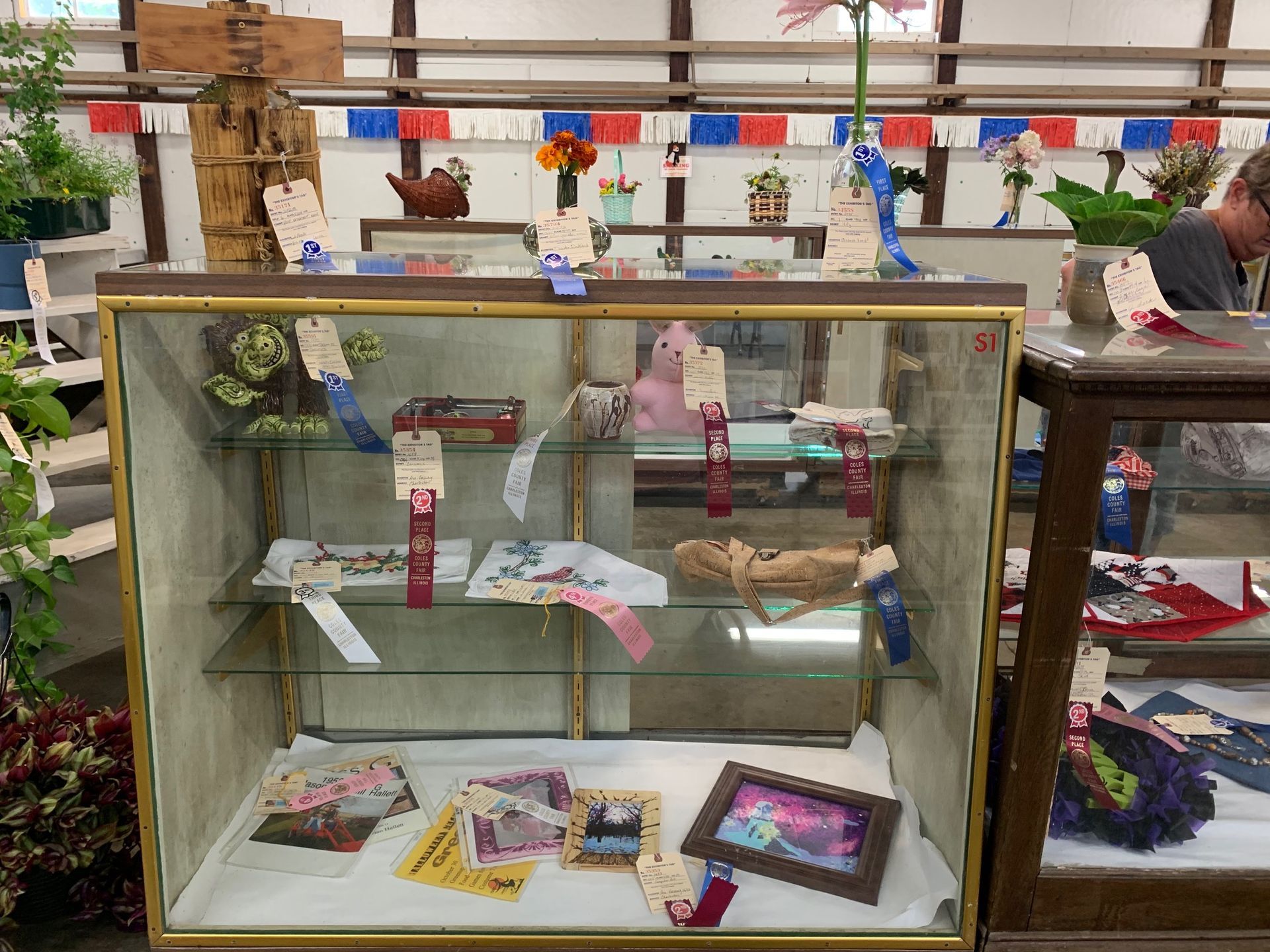 A glass display case with pictures and ribbons on it
