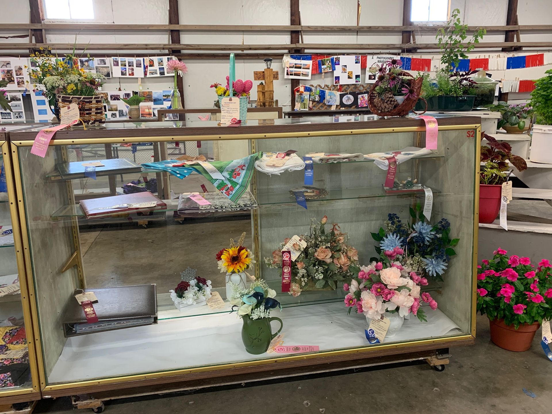 A glass display case filled with flowers and other items