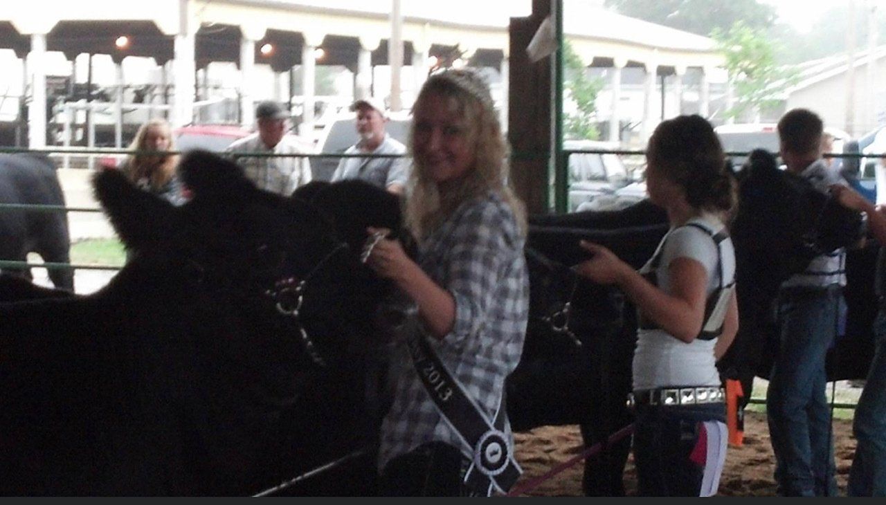 A woman with a ribbon around her neck that says 2013