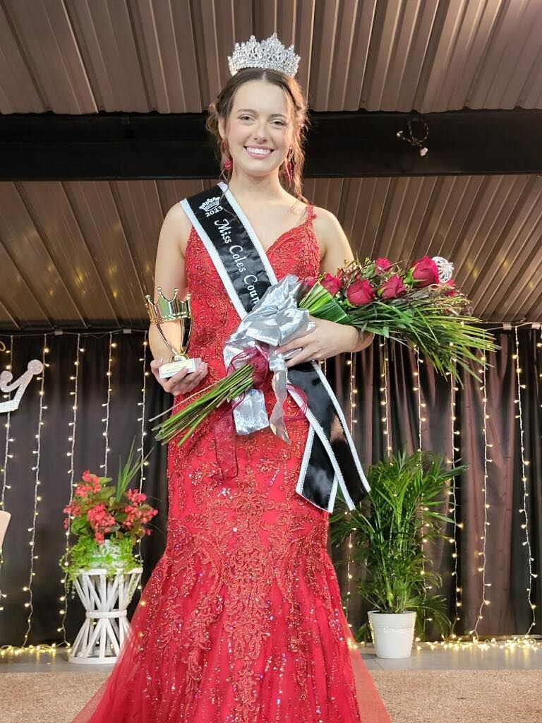 A woman in a red dress is holding a bouquet of flowers.