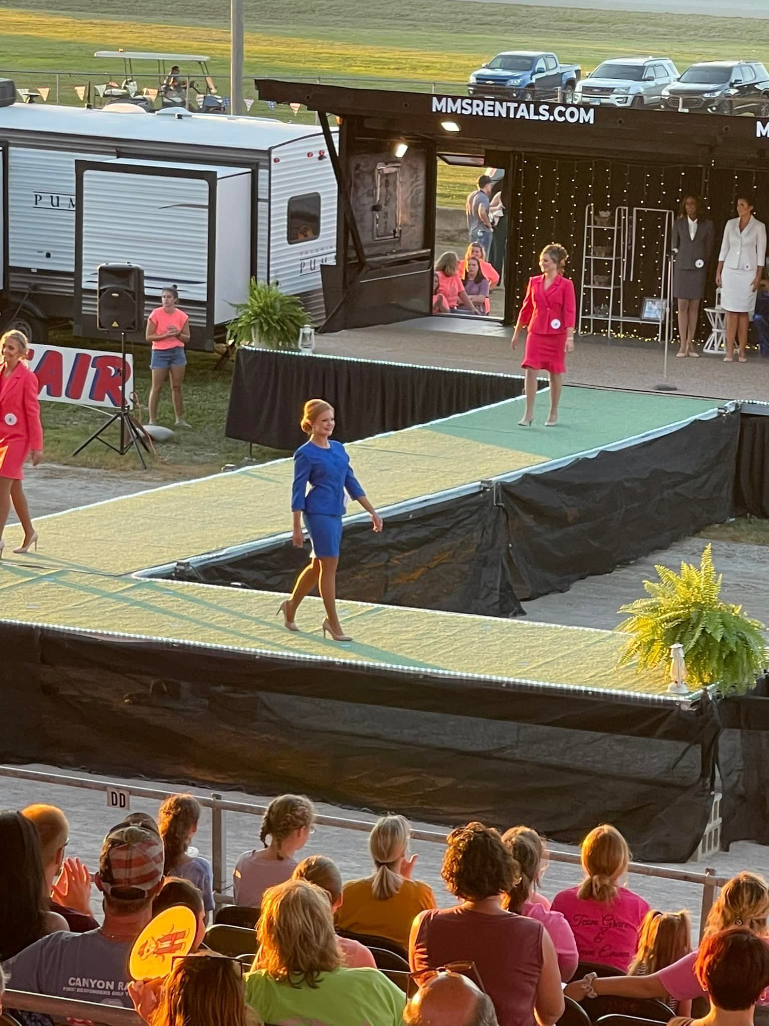 A group of people are watching a fashion show on a stage.