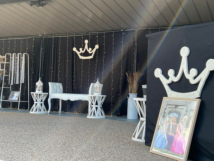 A room with a crown on the wall and a picture on the floor.