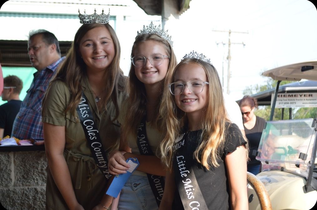Three girls wearing sashes that say little miss country