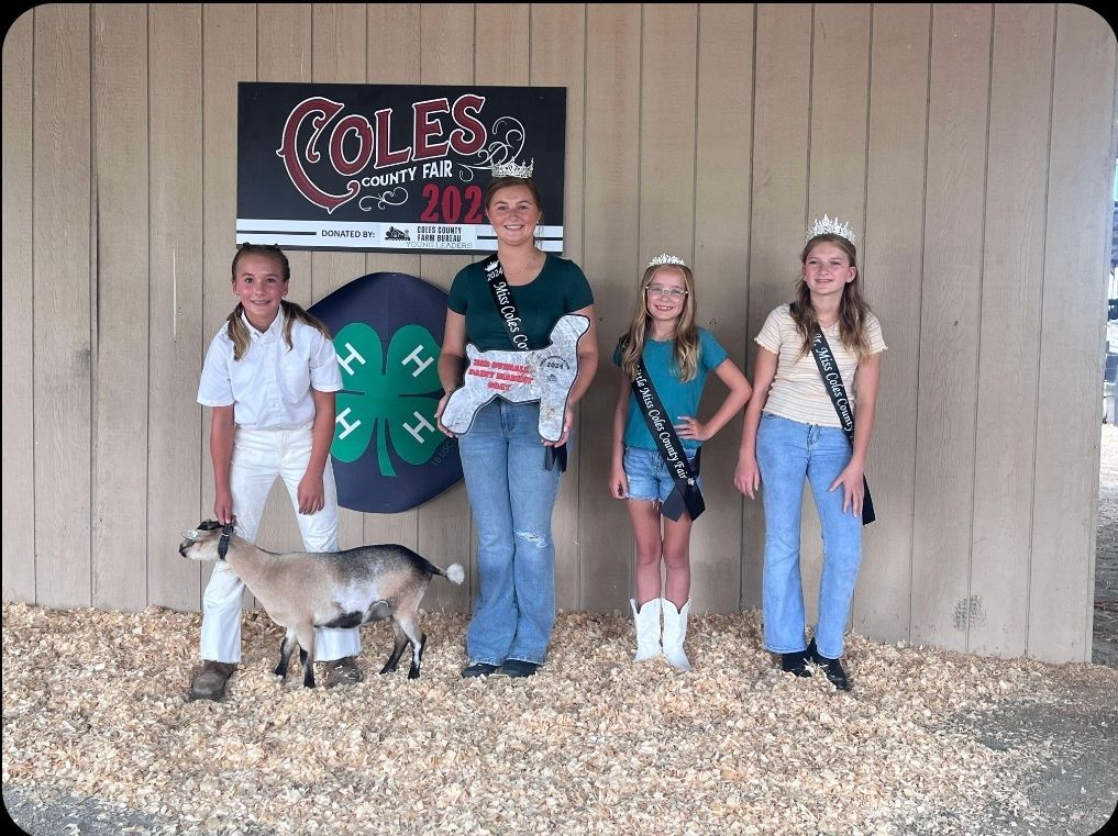 A group of girls standing in front of a sign that says coles