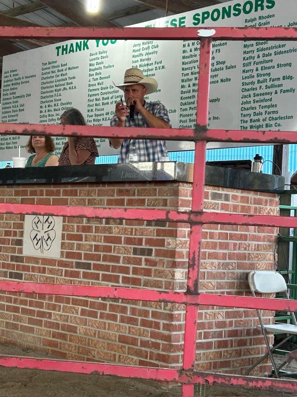 A man stands in front of a sign that says sponsors