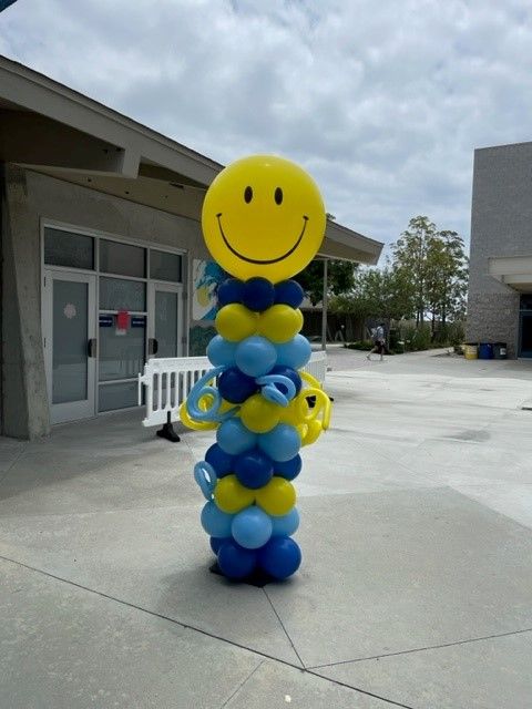Yellow smiley column balloons