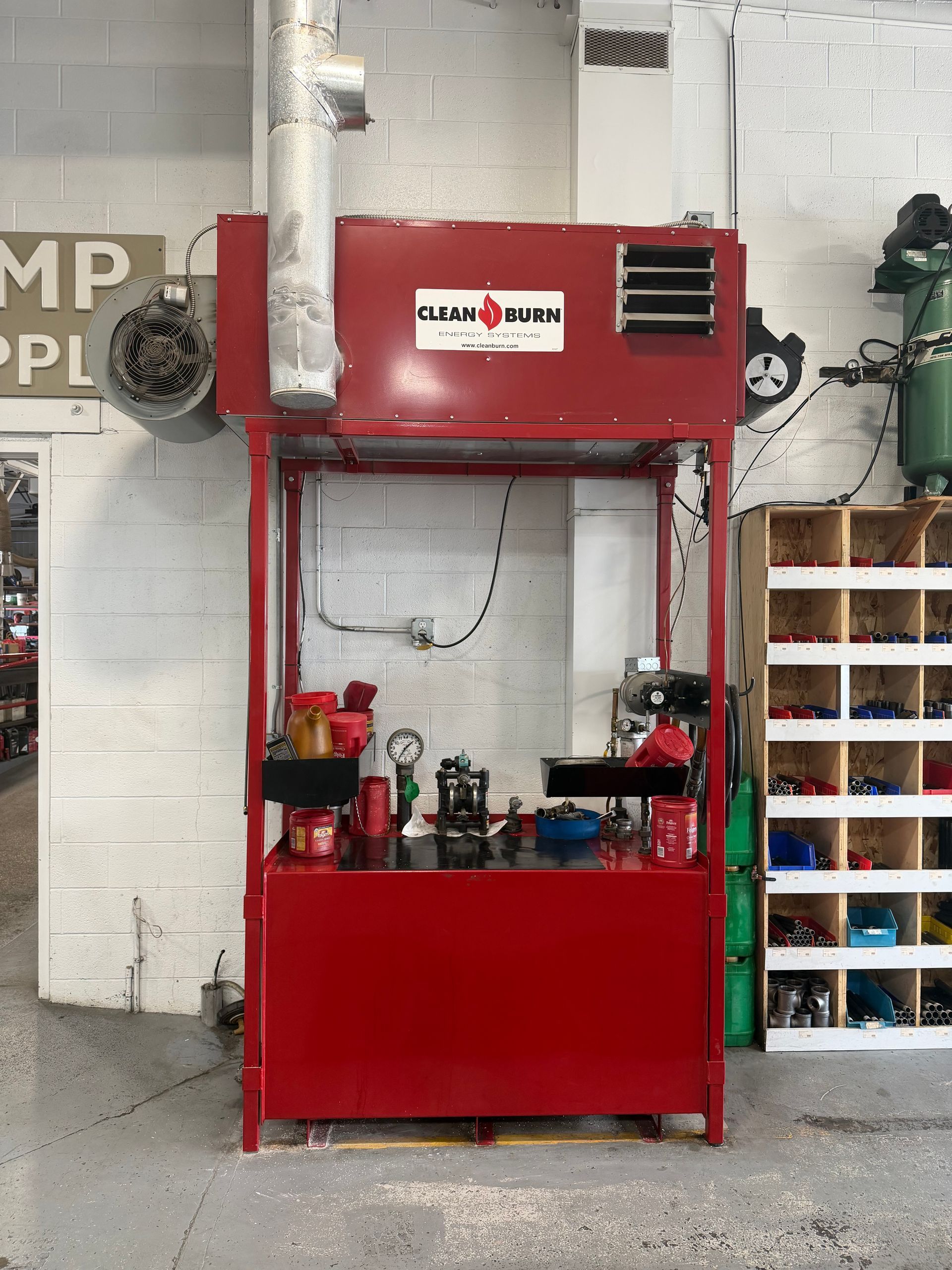 Red industrial machine with tools on a counter inside a workshop.
