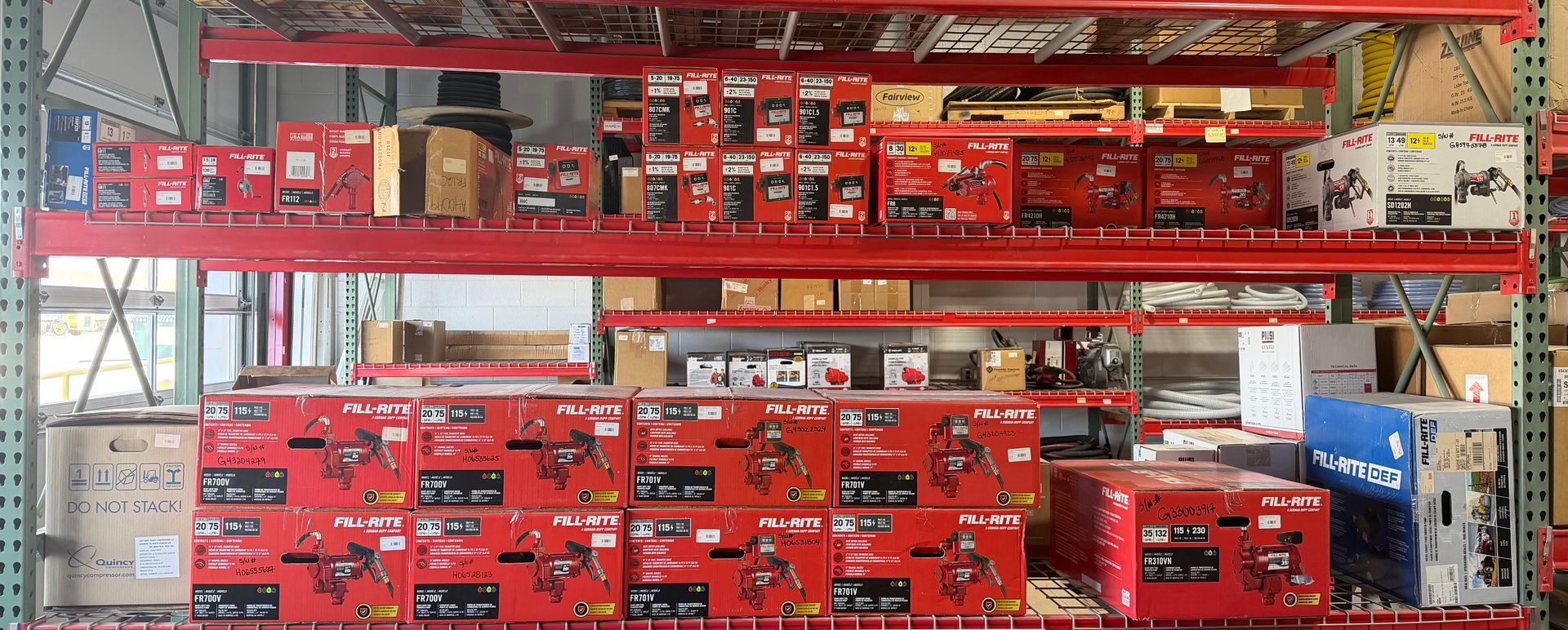 Shelves stocked with red boxed tools and hardware in a store aisle.