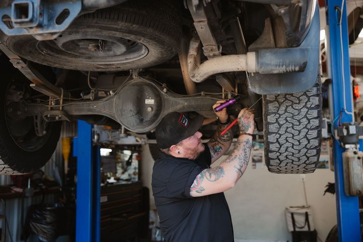 A man is working on the engine of a car.