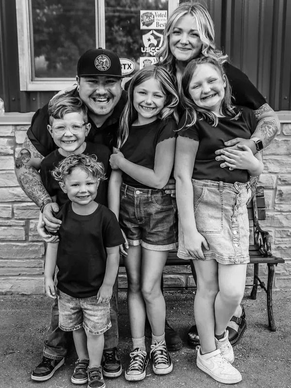 A black and white photo of a family posing for a picture.