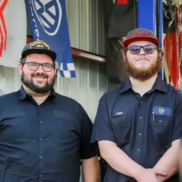 Two men standing next to each other with one wearing a hat that says usa