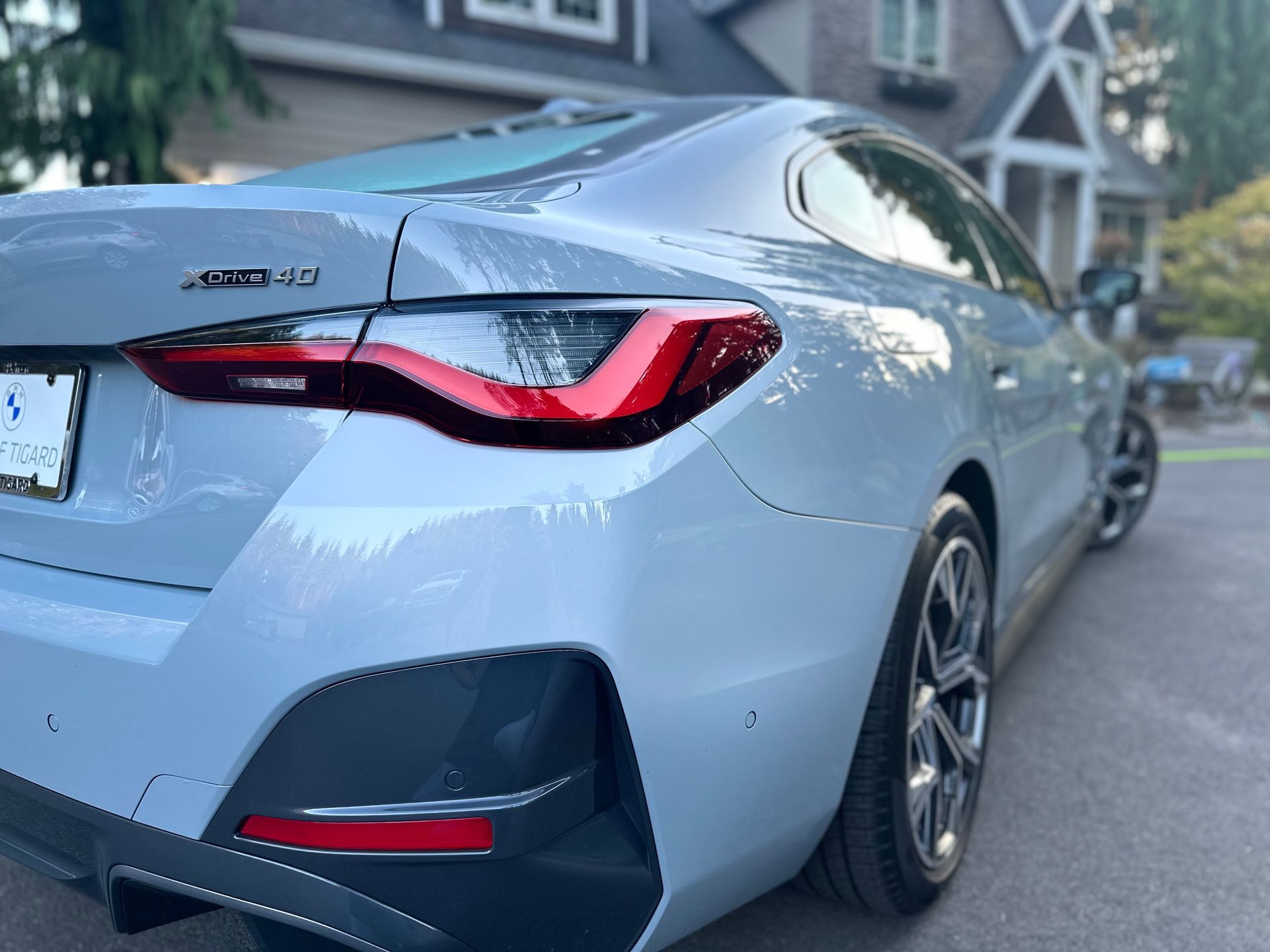 A gray car is parked in front of a house.