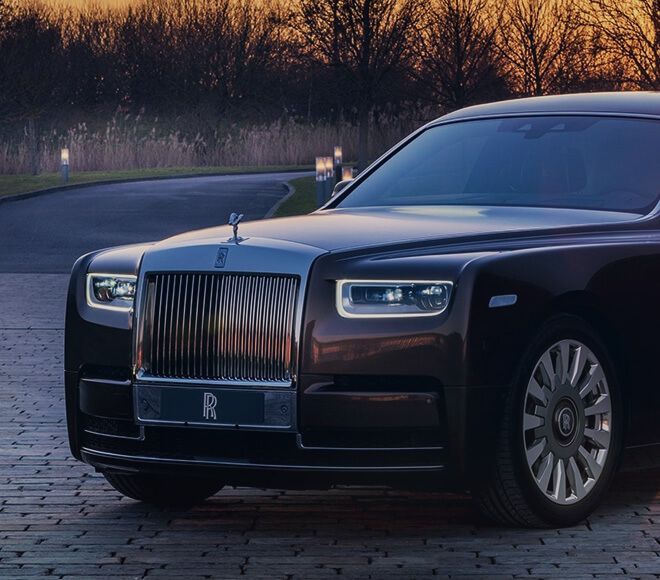 A rolls royce phantom is parked on a brick driveway.