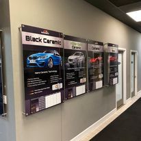 A row of signs hanging on a wall in a hallway.