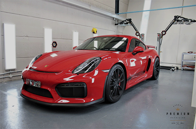 A red sports car is parked in a garage.