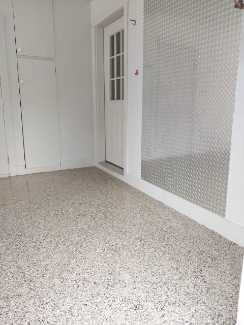 A room with a door and a mirror on the wall.