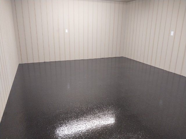 An empty room with a black floor and white walls.