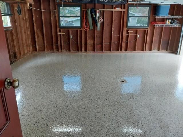 A room with a white floor and a red door