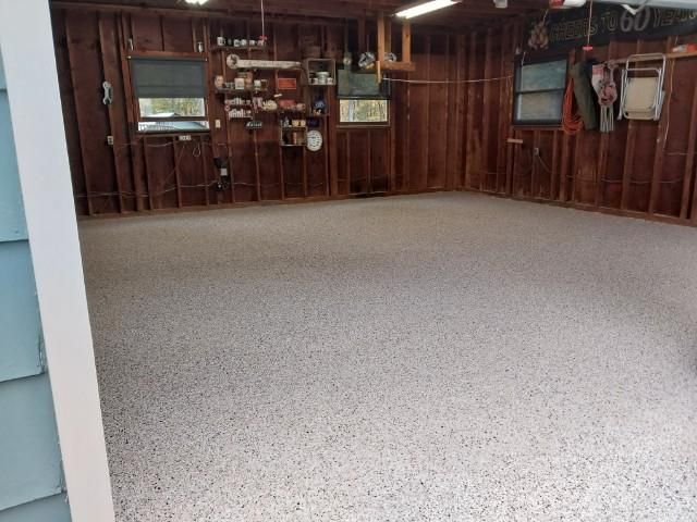 A garage with a concrete floor and wooden walls.