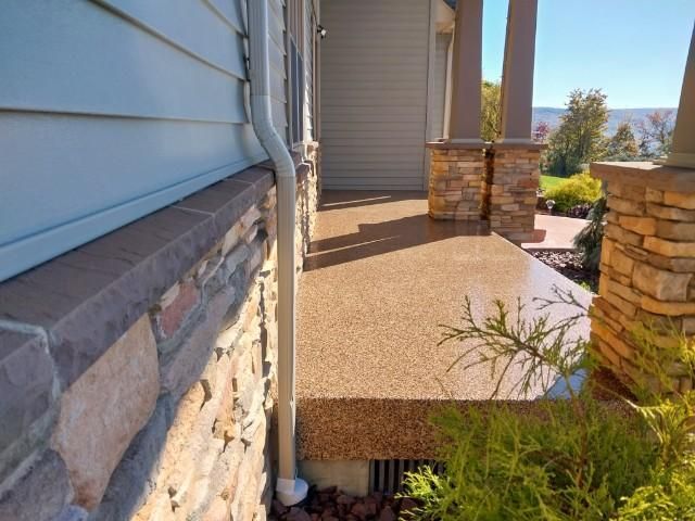 A house with a porch and a stone wall