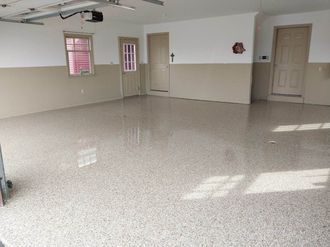 An empty garage with a concrete floor and white walls.