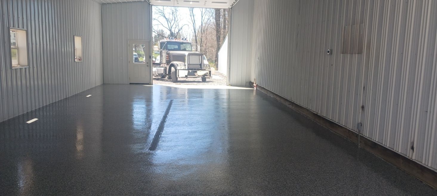 A truck is parked in a garage with a shiny floor.