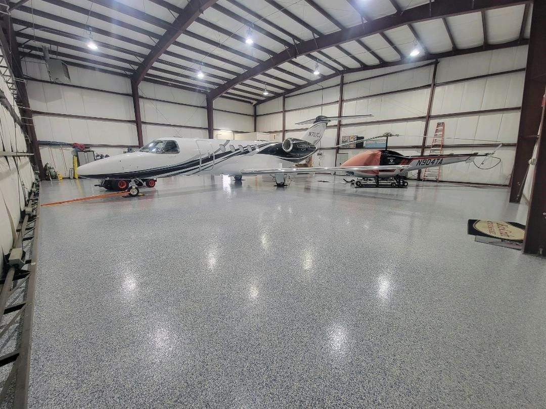 A plane is parked in a hangar with other planes.