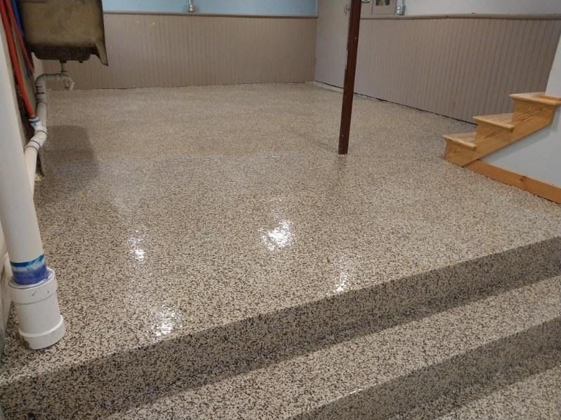 A basement with stairs and a shiny floor.