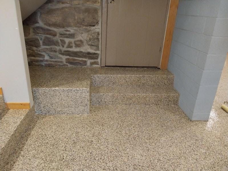Stairs leading up to a stone wall and a door.