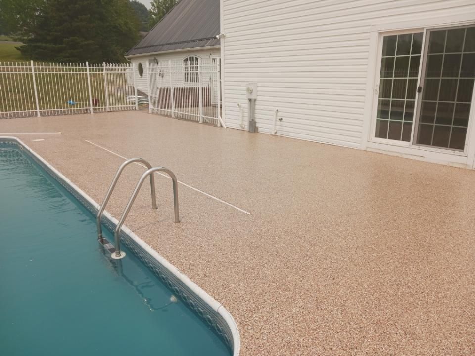 A swimming pool with a deck and stairs next to a house.