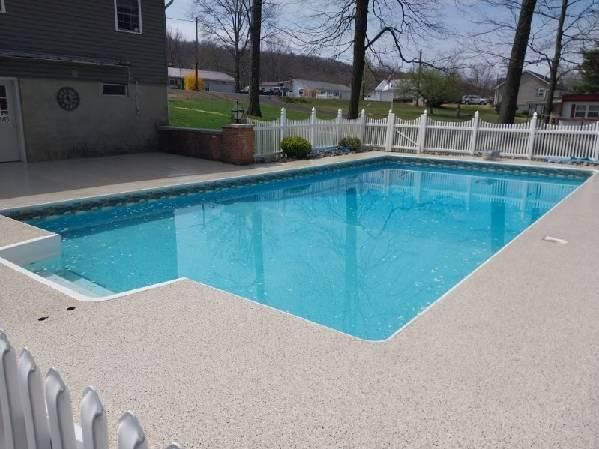A large swimming pool with a white fence around it