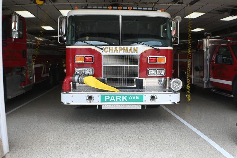 A red chapman fire truck is parked in a garage