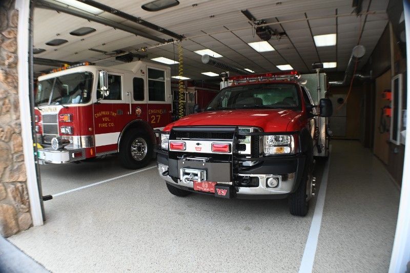 Two fire trucks are parked in a garage.