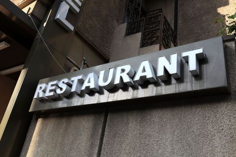 Restaurant sign on a building exterior, with large white letters on a dark awning.