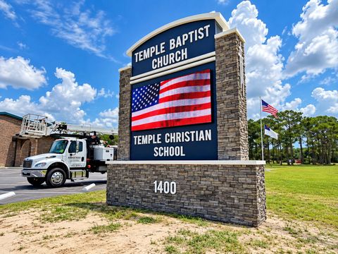 Temple Baptist Church and Temple Christian School sign with U.S. flag graphic by a road, numbered 1400