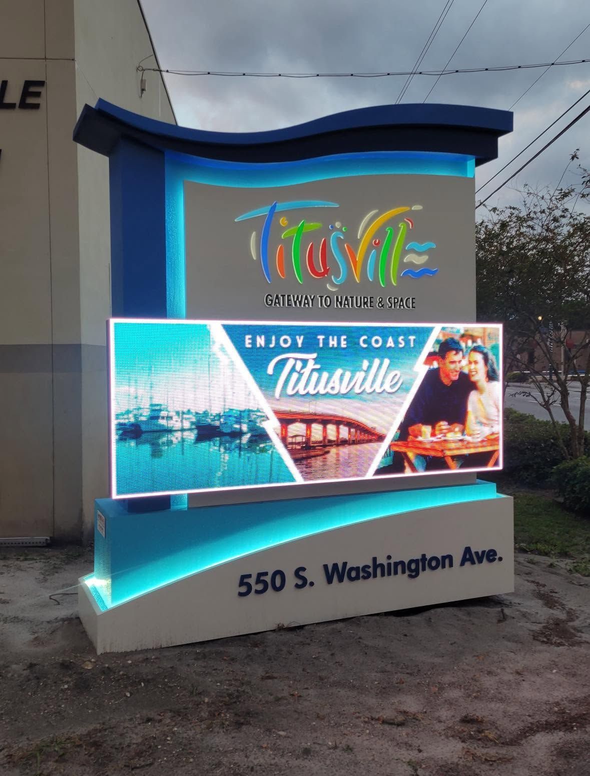 Colorful illuminated tourist sign reading “Trust” at 550 S. Washington Ave.